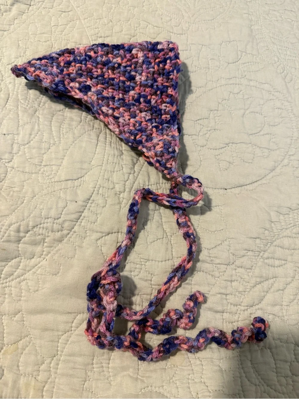 Handmade crochet bandana in pink, blue, and purple marbled yarn.